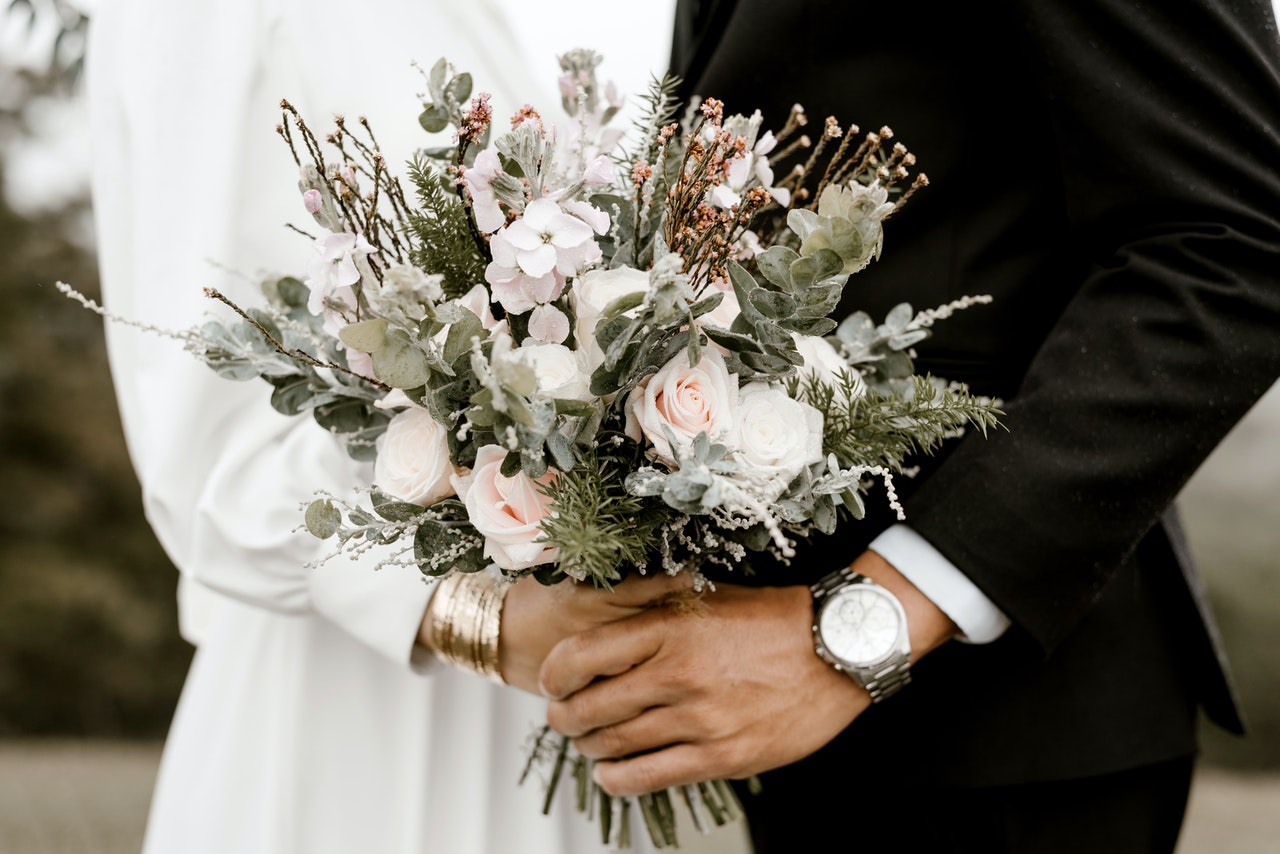 Brud og mand holder blomster sammen til bryllup